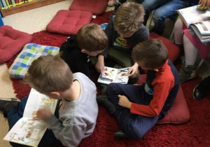 Czterech chłopców ogląda książki